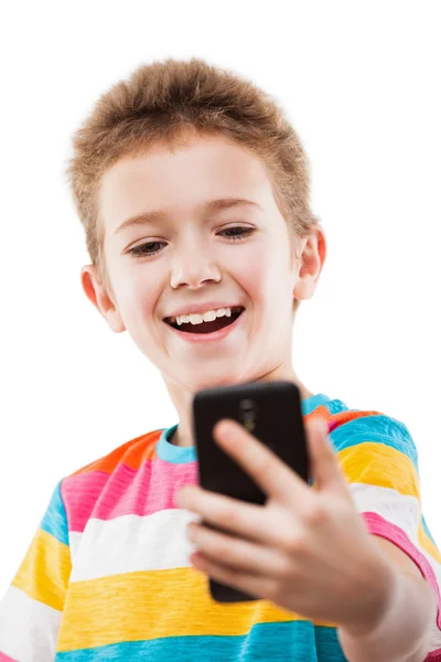 Smiling child boy holding mobile phone or smartphone taking self — Stock Photo, Image