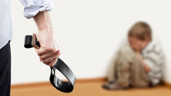 Angry man raised hand holding leather belt over wall corner sitt — Stock Photo, Image