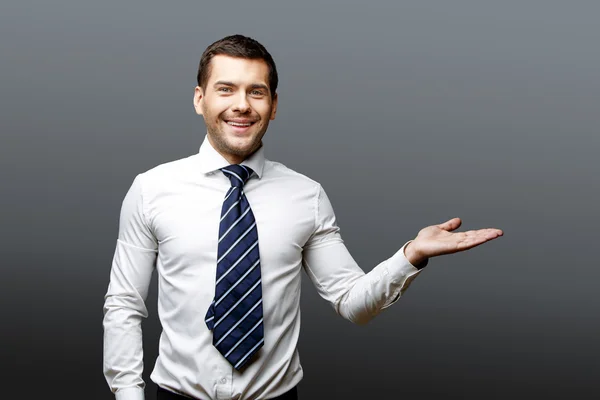 Bonito homem de negócios elegante em fundo cinza — Fotografia de Stock