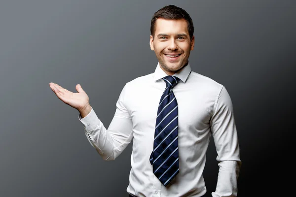 Bonito homem de negócios elegante em fundo cinza — Fotografia de Stock