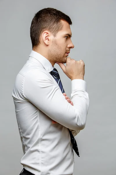 Guapo hombre de negocios con estilo sobre fondo gris — Foto de Stock