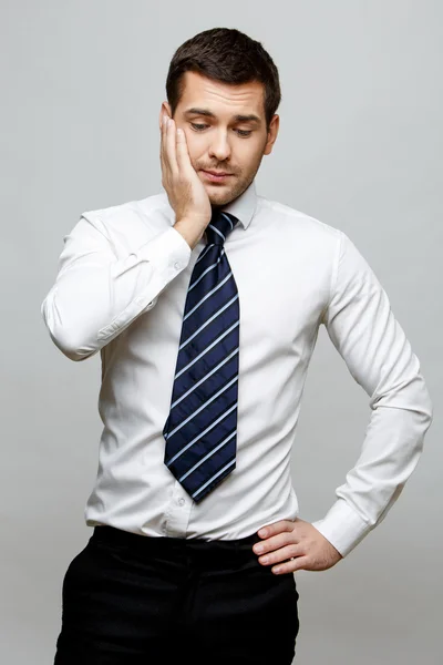 Bonito homem de negócios elegante em fundo cinza — Fotografia de Stock