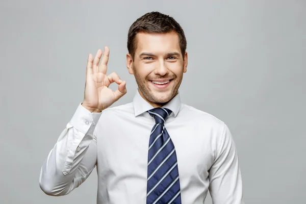 Bello uomo d'affari elegante su sfondo grigio — Foto Stock