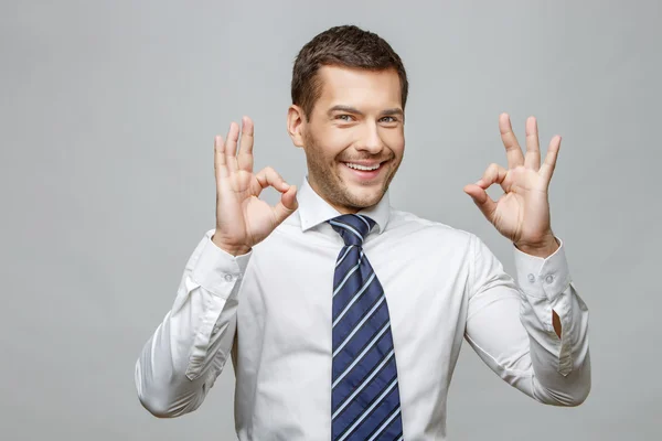 Bello uomo d'affari elegante su sfondo grigio — Foto Stock