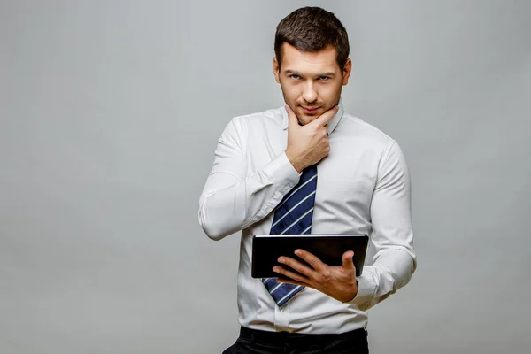 Guapo hombre de negocios con estilo sobre fondo gris — Foto de Stock