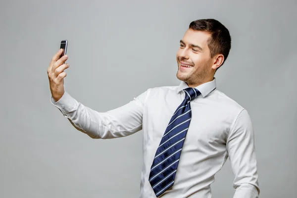 Bonito homem de negócios elegante em fundo cinza — Fotografia de Stock