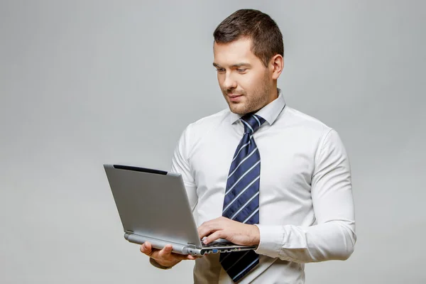 Handsome stylish businessman on grey background — Stock Photo, Image