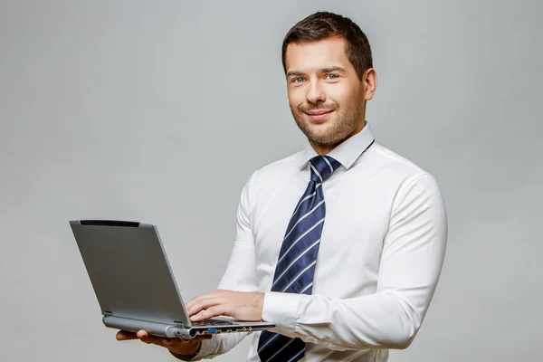 Handsome stylish businessman on grey background — Stock Photo, Image