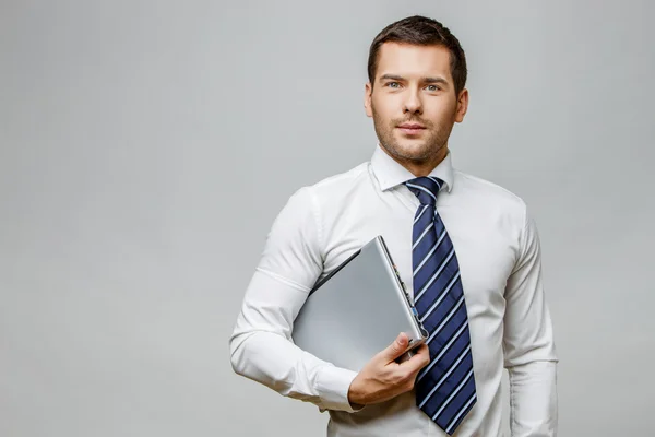 Knappe stijlvolle zakenman op grijze achtergrond — Stockfoto