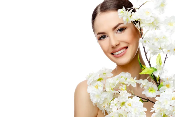 Mulher bonita com pele fresca limpa segurando ramos floridos — Fotografia de Stock