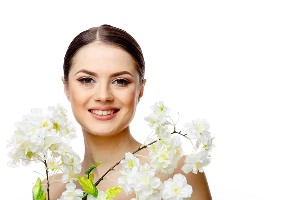 Vacker kvinna med ren fräsch hud håller blommande grenar — Stockfoto