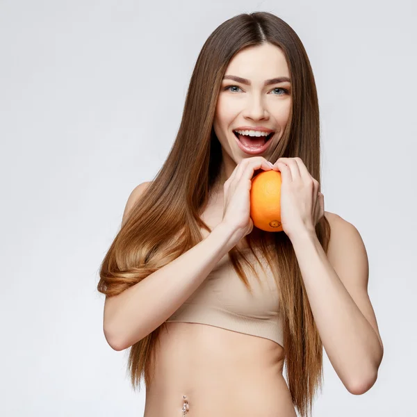 Vacker kvinna med ren fräsch hud håller orange — Stockfoto