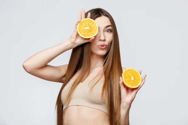 Piękna kobieta z czystą skórę świeżą, trzymając pomarańczowe — Zdjęcie stockowe