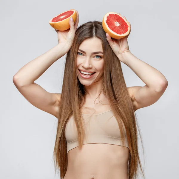 Vacker kvinna med ren fräsch hud som håller garapefruit — Stockfoto