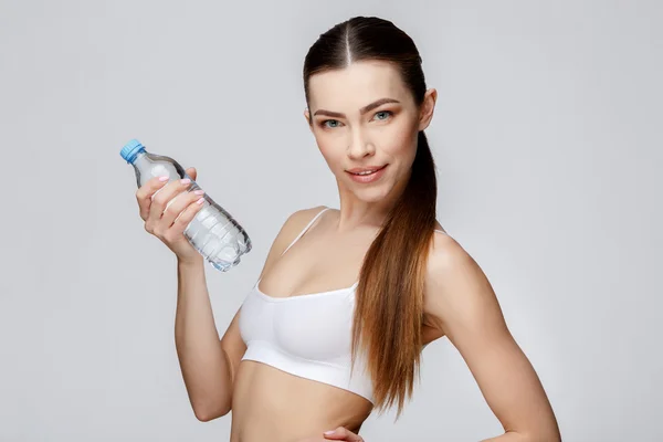 Спортивна жінка над сірим фоном питна вода — стокове фото
