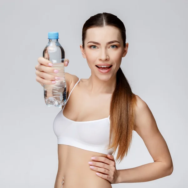 Mujer deportiva sobre fondo gris agua potable —  Fotos de Stock