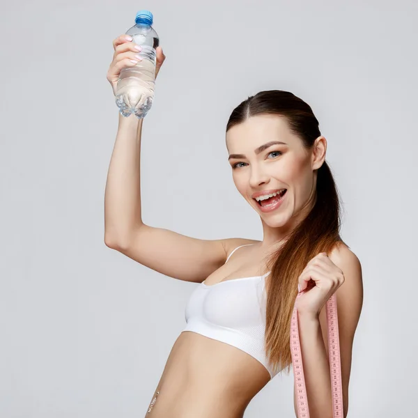 Спортивна жінка над сірим фоном питна вода — стокове фото