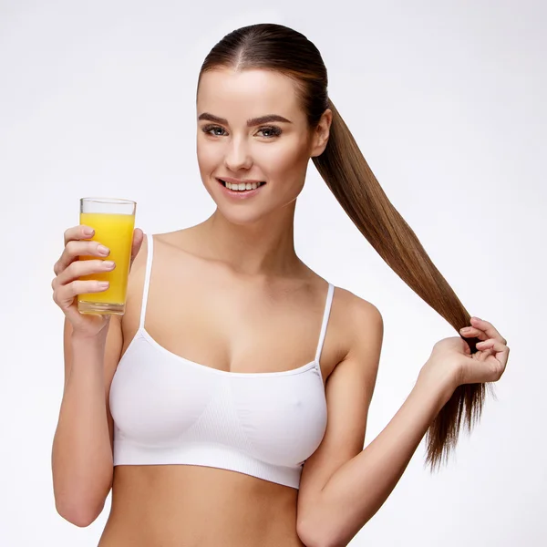 Atractivesmiling mujer sosteniendo vaso de jugo de naranja aislado en blanco —  Fotos de Stock