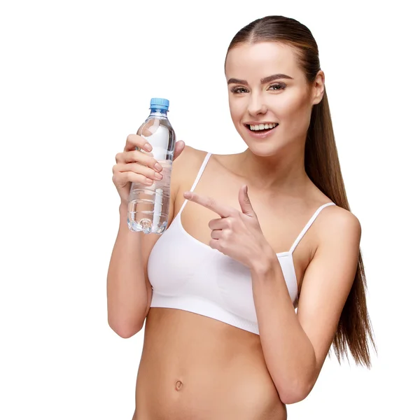 Attraente donna sorridente in possesso di bottiglia d'acqua isolata su bianco — Foto Stock