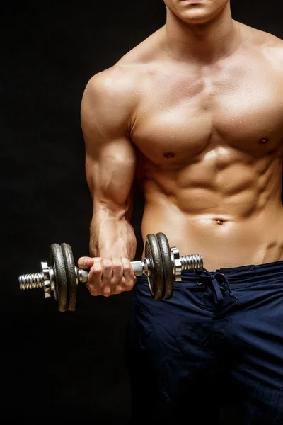 Shirtless fisiculturista segurando dumbell e mostrando seus braços musculares . — Fotografia de Stock