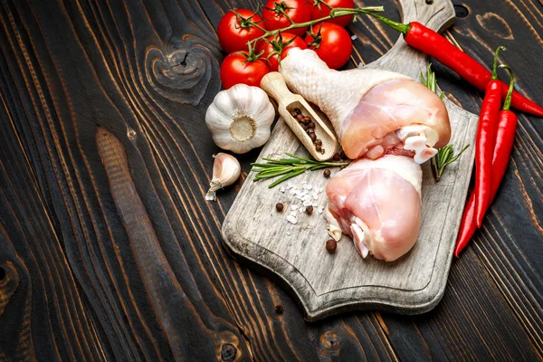 Jambes de poulet crues dans un plat de cuisson sur un fond en bois — Photo