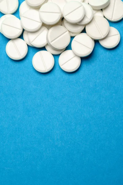 Groupe de pilules blanches ou comprimés sur fond bleu — Photo