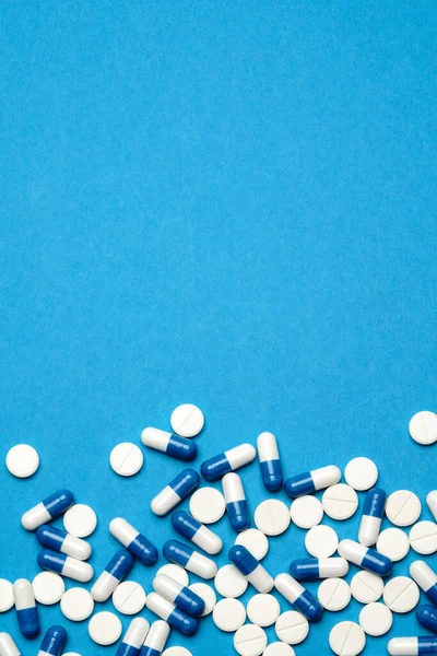 Tabletták vagy kapszulák csoportja kék alapon — Stock Fotó