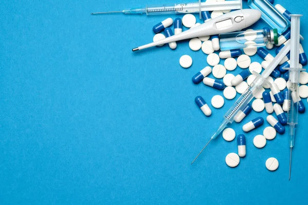 Top kilátás tabletták, fecskendő, hőmérő és ampulla vakcinázással Kék háttér fénymásoló hely — Stock Fotó