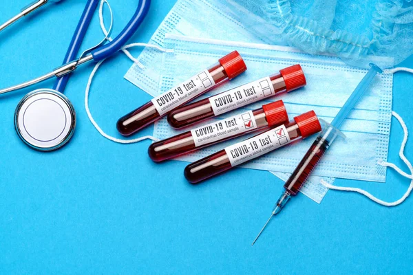 Tıbbi laboratuvar kavramı - Mavi arka planda test tüplerinde ve şırıngalarda Covid-19 kan örnekleri grubu — Stok fotoğraf