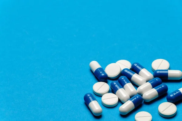Groupe de pilules ou capsules sur fond bleu — Photo