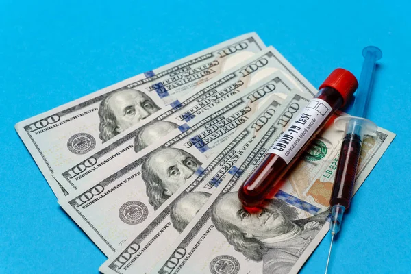 파란 배경 위의 시험관에서 100 미국 달러 지폐와 혈액 샘플을 닫습니다. — 스톡 사진