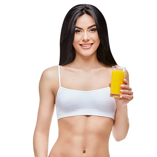 Sportig kvinna över grå bakgrund hålla glas apelsinjuice — Stockfoto