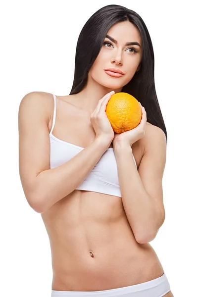 Studio strzał atrakcyjnej młodej kobiety z pięknym ciałem gospodarstwa pomarańczowy odizolowany na białym — Zdjęcie stockowe