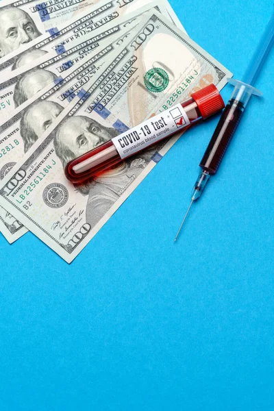 파란 배경 위의 시험관에서 100 미국 달러 지폐와 혈액 샘플을 닫습니다. — 스톡 사진