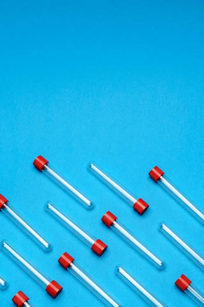 Visão superior dos tubos de ensaio de medicamentos para amostras de sangue sobre fundo azul — Fotografia de Stock