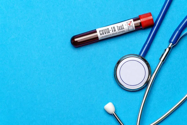 Medizinische Geräte von oben auf blauem Hintergrund - Stethoskop und Reagenzglas - Gesundheits- und Medizinkonzept — Stockfoto