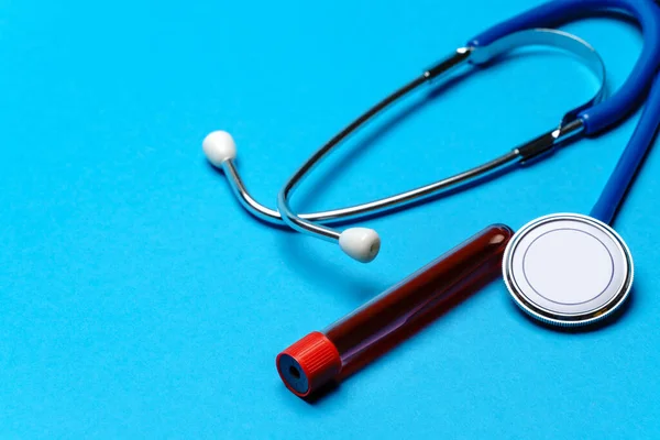 Pohled shora na lékařské vybavení na modrém pozadí - stetoskop a zkumavka - koncept zdravotnictví a medicíny — Stock fotografie