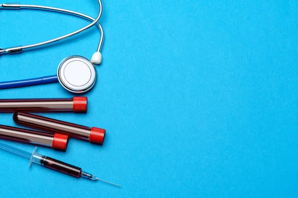 Orvosi berendezések felső nézete kék háttéren - sztetoszkóp, fecskendő és kémcső - egészségügyi és gyógyászati koncepció — Stock Fotó
