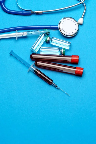 청진기, 주사기, 혈액 표본과 검은 색 배경 위에 약품이나 백신으로 만든 관을 검사 한다 — 스톡 사진