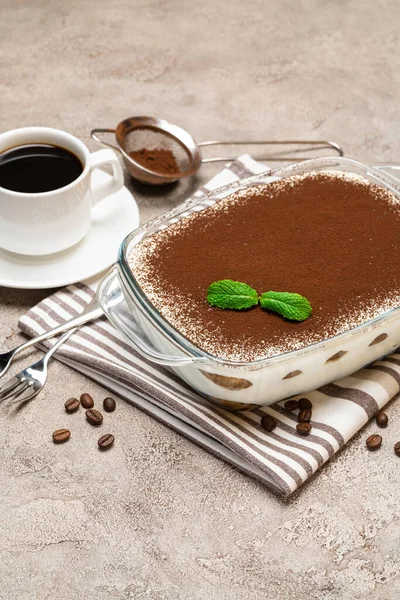 Hagyományos olasz Tiramisu desszert üvegsütőben és csésze friss forró eszpresszó kávé beton alapon — Stock Fotó