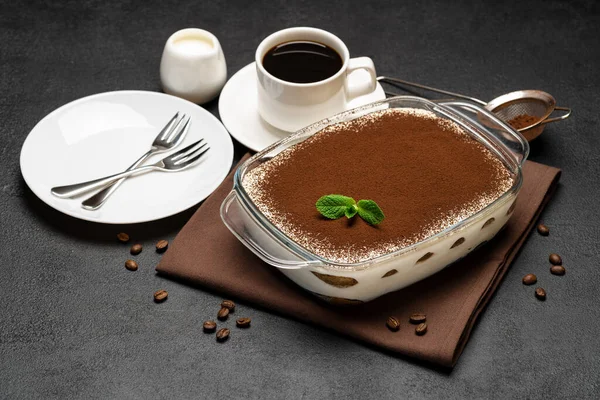 Traditionele Italiaanse Tiramisu dessert in glazen bakvorm en kopje verse hete espresso koffie op betonnen achtergrond — Stockfoto