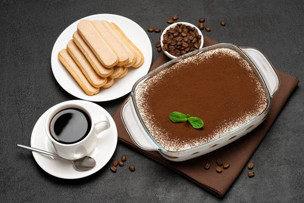 Hagyományos olasz Tiramisu desszert üvegsütőben és csésze friss forró eszpresszó kávé beton alapon — Stock Fotó