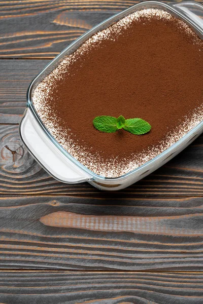 Postre Tiramisú tradicional italiano en bandeja de vidrio sobre fondo de madera —  Fotos de Stock