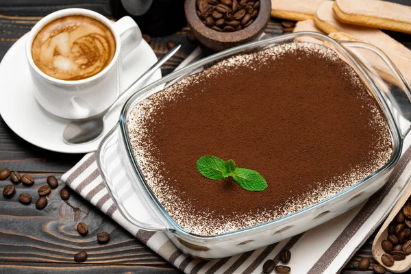Hagyományos olasz Tiramisu desszert üveg sütő edényben, kávédaráló, savoiardi cookie-k és egy csésze friss forró eszpresszó kávé fa alapon — Stock Fotó
