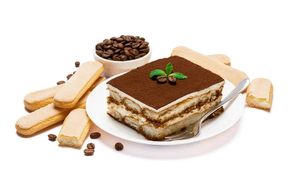 Traditional Italian Tiramisu square dessert portion on ceramic plate, savoiardi cookies and coffee beans isolated on white — Stock Photo, Image