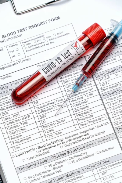 Clipboard with paper blank form with blood test tubes on blue background — Stock Photo, Image