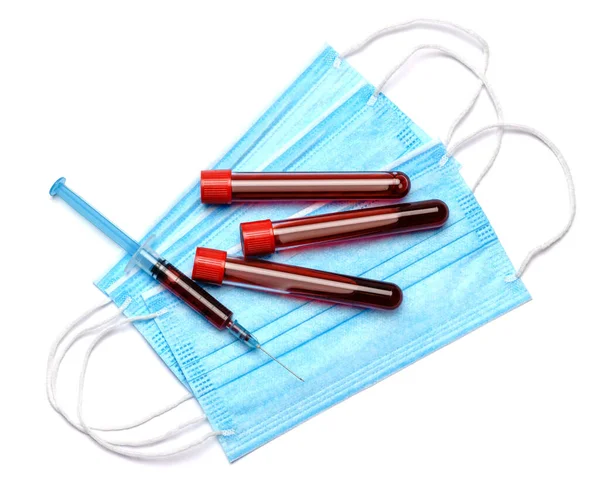 주사기가 달린 혈액 검사 튜브, 흰 배경의 의료용 마스크, 맨 위 뷰 — 스톡 사진