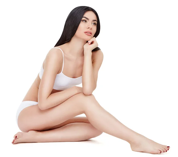 Фітнес молода жінка з красивим тілом, що сидить на білому тлі — стокове фото