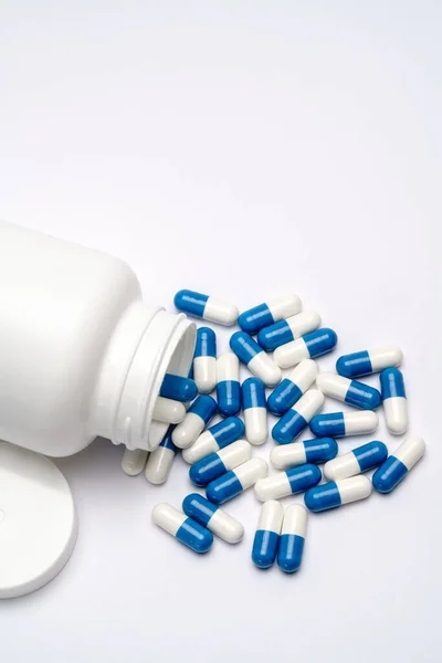 Medicijnen capsules en witte plastic fles op lichtgrijze achtergrond — Stockfoto