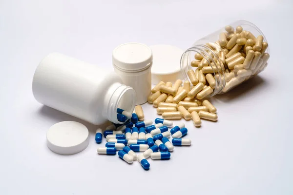 Medicijnen capsules in plastic flessen op lichtgrijze achtergrond — Stockfoto